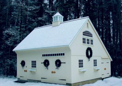 White Saltbox in the snow with wreaths on building